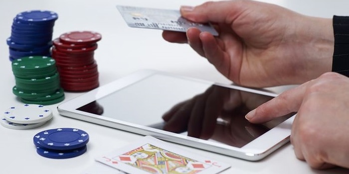 a person gambling with an ipad and a credit card