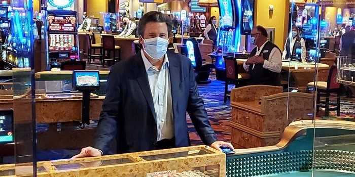 beau rivage employee stands at a gaming table wearing a mask to prevent the spread of the coronavirus