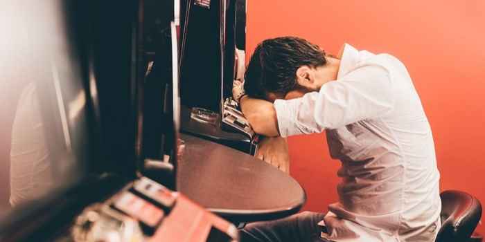 sad gambler in a casino at a slot machine