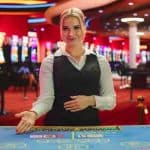 Live dealer sits at table